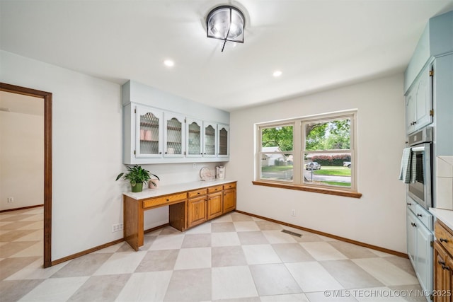 6123 E 53rd St, Tulsa, OK 74135 - kitchen featuring stainless steel oven, light countertops, light floors, glass insert cabinets, and recessed lighting