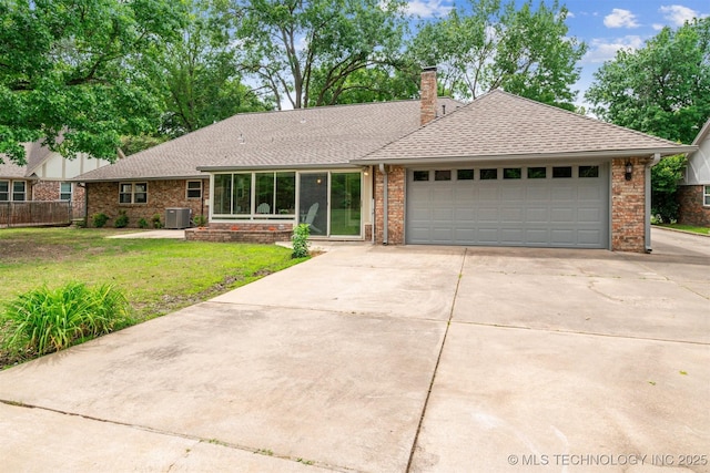 6123 E 53rd St, Tulsa, OK 74135 - view of front facade with driveway, a garage, a shingled roof, and brick siding