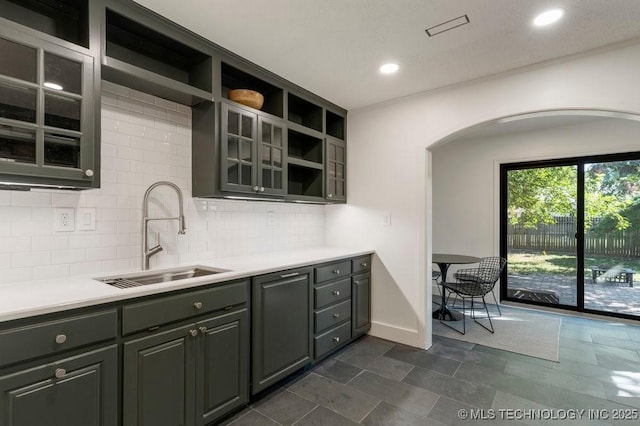 4907 S Boston Ave, Tulsa, OK 74105 - kitchen featuring a sink, open shelves, arched walkways, decorative backsplash, and light countertops