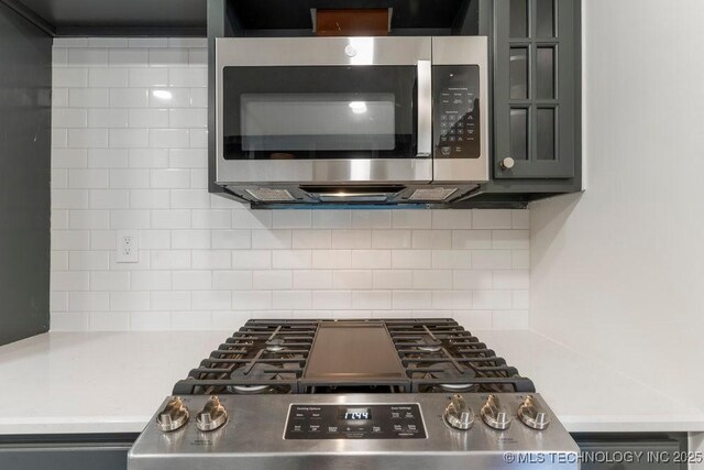 4907 S Boston Ave, Tulsa, OK 74105 - kitchen featuring appliances with stainless steel finishes, tasteful backsplash, gray cabinetry, and light countertops