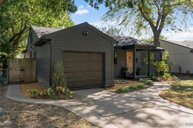 4907 S Boston Ave, Tulsa, OK 74105 - view of front facade with an attached garage, concrete driveway, a gate, and fence
