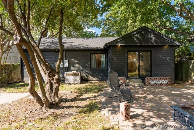 4907 S Boston Ave, Tulsa, OK 74105 - rear view of property with fence, a patio, and roof with shingles