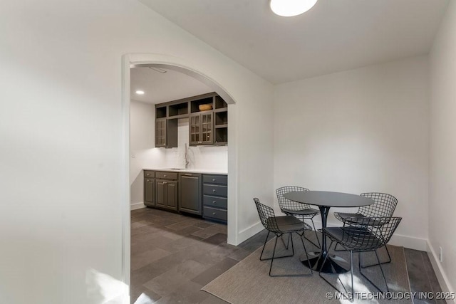 4907 S Boston Ave, Tulsa, OK 74105 - dining space featuring arched walkways, baseboards, and dark wood finished floors