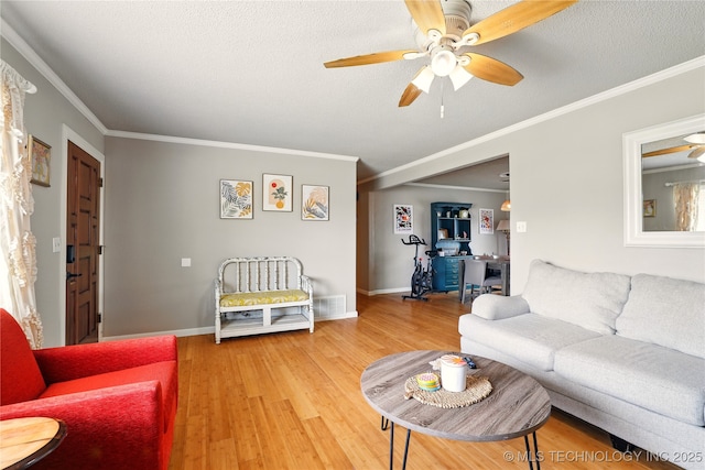 300 Michele, Calera, OK 74730 - living room featuring a ceiling fan, light wood finished floors, ornamental molding, baseboards, and a textured ceiling