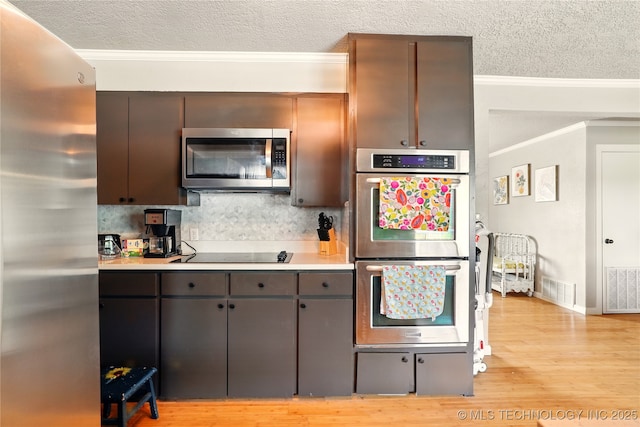 300 Michele, Calera, OK 74730 - kitchen featuring appliances with stainless steel finishes, a textured ceiling, crown molding, light wood-style flooring, and light countertops
