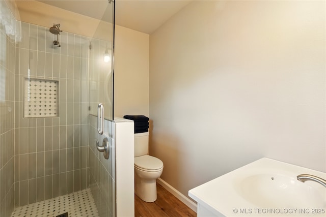 300 Michele, Calera, OK 74730 - bathroom featuring a stall shower, toilet, wood finished floors, a sink, and baseboards