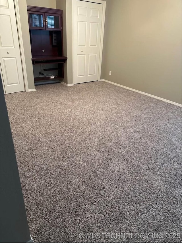 unfurnished room featuring carpet floors and baseboards