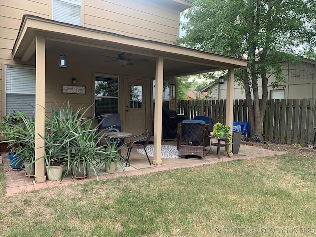 view of exterior entry featuring ceiling fan and a patio