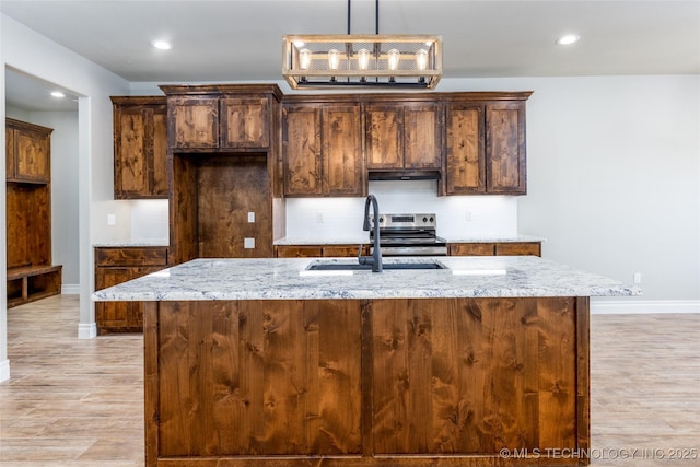 204 Maple Leaf, Durant, OK 74701 - kitchen with a sink, baseboards, light stone countertops, decorative backsplash, and a kitchen island with sink