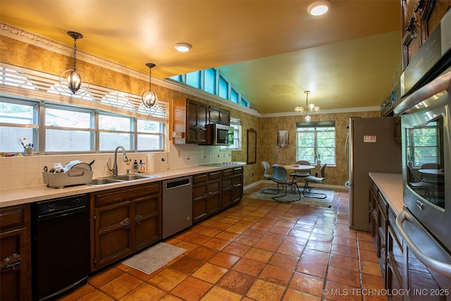4207 Denison St, Muskogee, OK 74401 - kitchen featuring appliances with stainless steel finishes, a sink, vaulted ceiling, light countertops, and decorative light fixtures