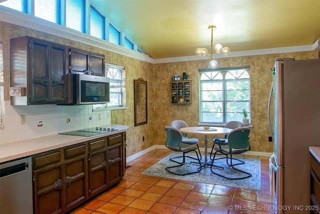 4207 Denison St, Muskogee, OK 74401 - kitchen featuring appliances with stainless steel finishes, vaulted ceiling, light countertops, a chandelier, and light tile patterned floors