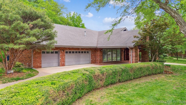 3219 S Birmingham Ave, Tulsa, OK 74105 - view of front of property featuring a garage, a front lawn, a shingled roof, brick siding, and driveway