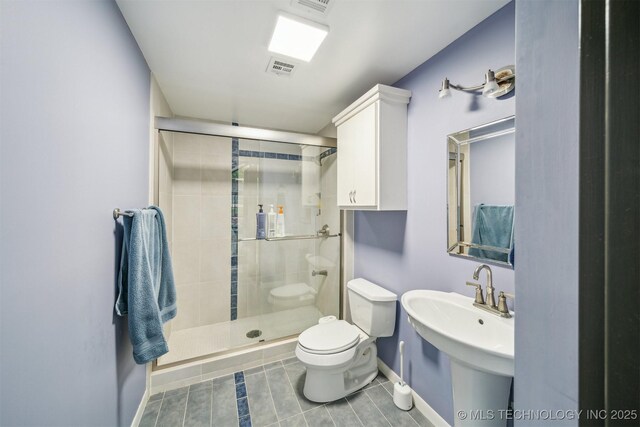 3219 S Birmingham Ave, Tulsa, OK 74105 - bathroom featuring baseboards, a shower stall, toilet, tile patterned floors, and a sink