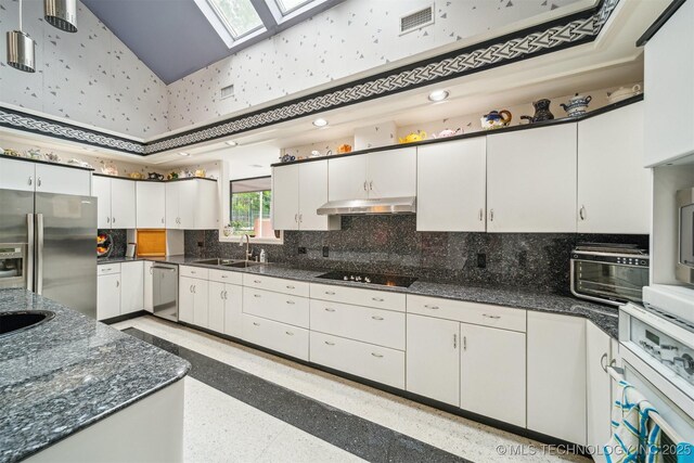 3219 S Birmingham Ave, Tulsa, OK 74105 - kitchen with stainless steel appliances, a sink, a skylight, white cabinets, and decorative backsplash