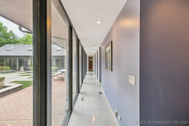 3219 S Birmingham Ave, Tulsa, OK 74105 - hallway with speckle patterned floor, baseboards, and floor to ceiling windows