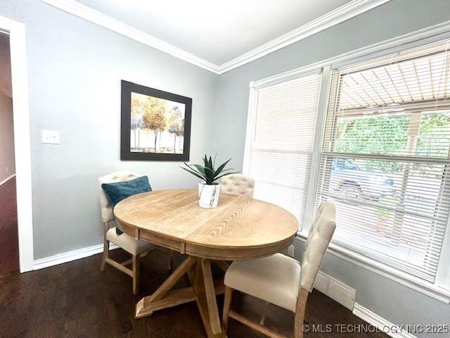 711 N SW, Ardmore, OK 73401 - dining space with baseboards, crown molding, and dark wood-type flooring