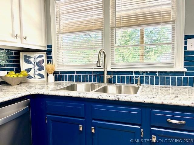711 N SW, Ardmore, OK 73401 - kitchen with blue cabinetry, a sink, dishwasher, and backsplash