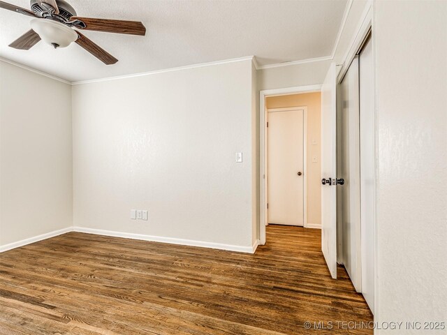 spare room featuring wood finished floors, ceiling fan, ornamental molding, and baseboards