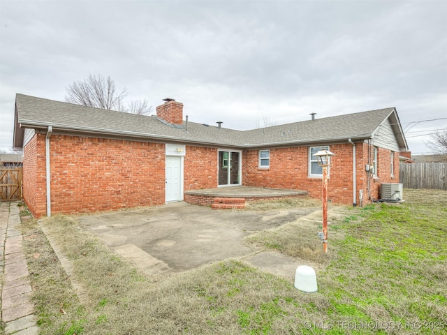 back of property with a patio, brick siding, a chimney, and cooling unit
