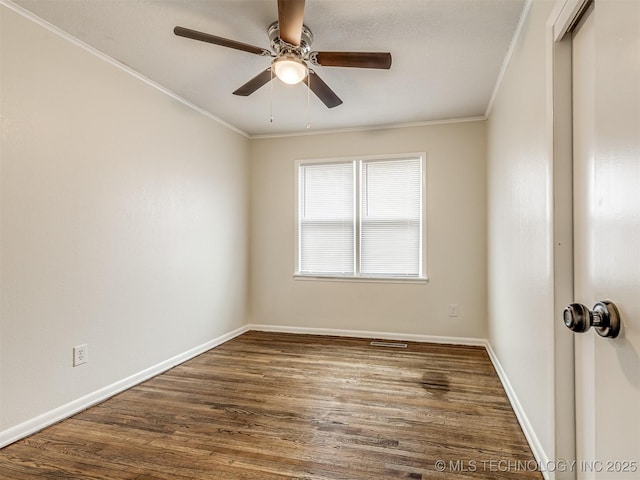 empty room featuring dark wood finished floors, ornamental molding, a ceiling fan, and baseboards