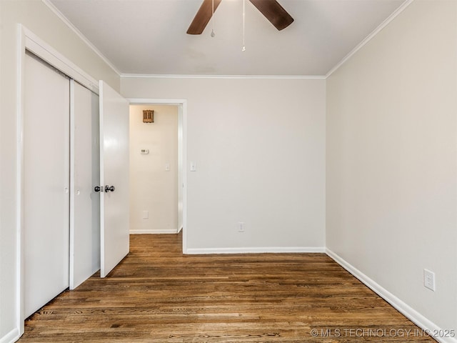 unfurnished bedroom with ornamental molding, wood finished floors, a closet, baseboards, and a ceiling fan