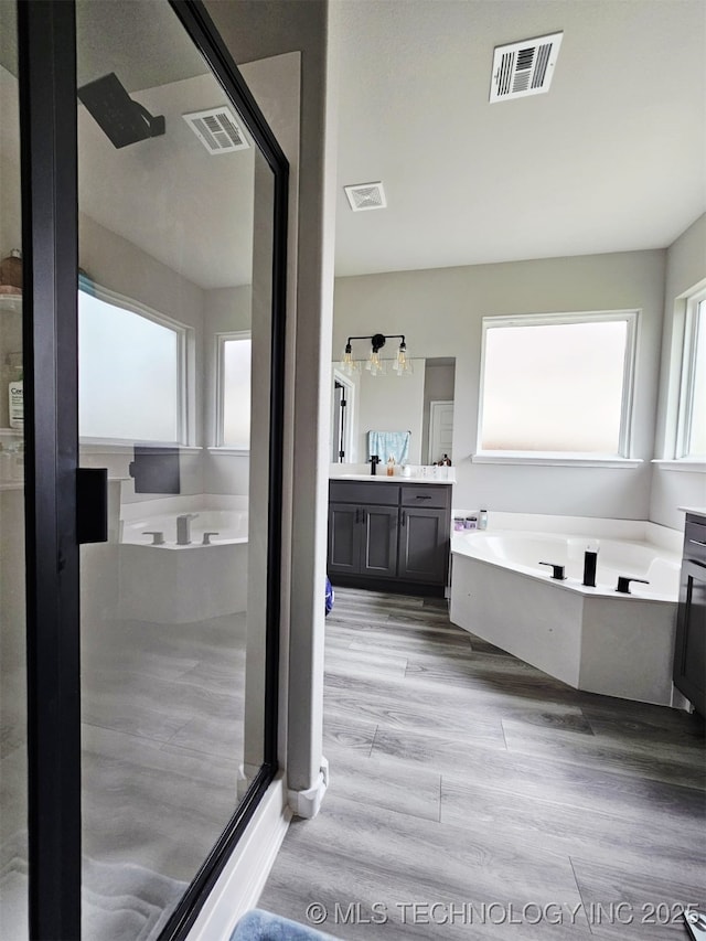 2721 S 8th St E, Broken Arrow, OK 74012 - full bathroom featuring a bath, vanity, wood finished floors, and a shower stall