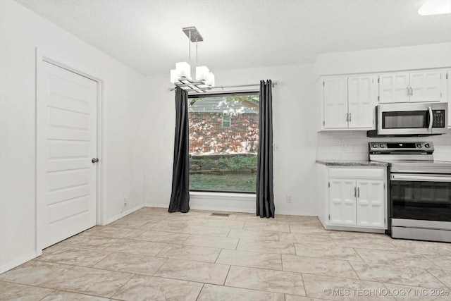 3719 E 84th St, Tulsa, OK 74137 - kitchen with appliances with stainless steel finishes, a chandelier, white cabinetry, light marble finish flooring, and a textured ceiling