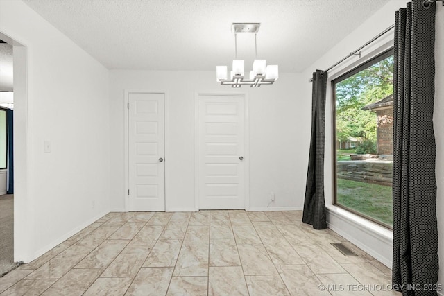 3719 E 84th St, Tulsa, OK 74137 - unfurnished dining area with a chandelier, a textured ceiling, and light marble finish flooring