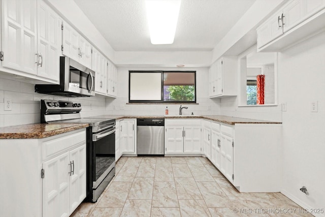 3719 E 84th St, Tulsa, OK 74137 - kitchen featuring appliances with stainless steel finishes, a sink, decorative backsplash, white cabinetry, and a textured ceiling