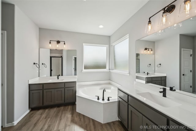 11807 N 131st E Ave, Owasso, OK 74055 - full bath featuring wood finished floors, a bath, two vanities, an enclosed shower, and recessed lighting