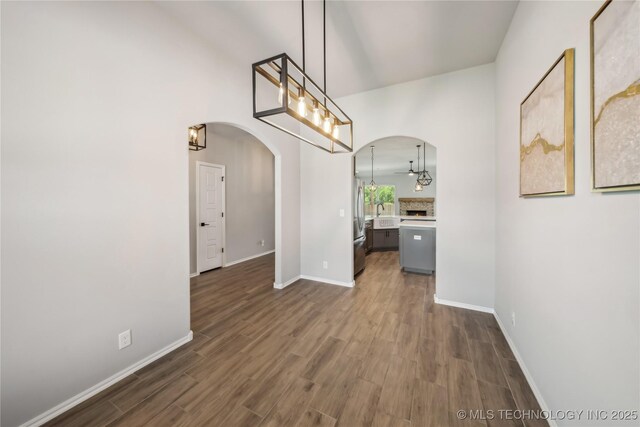 11807 N 131st E Ave, Owasso, OK 74055 - unfurnished dining area with arched walkways, dark wood-style floors, baseboards, and a chandelier