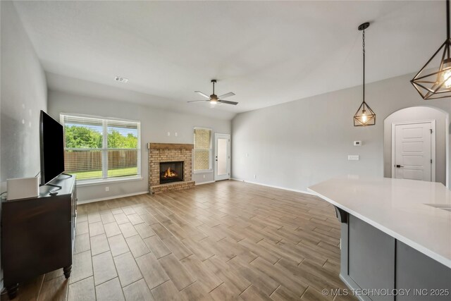 11807 N 131st E Ave, Owasso, OK 74055 - unfurnished living room with a ceiling fan, wood finished floors, a fireplace, and baseboards