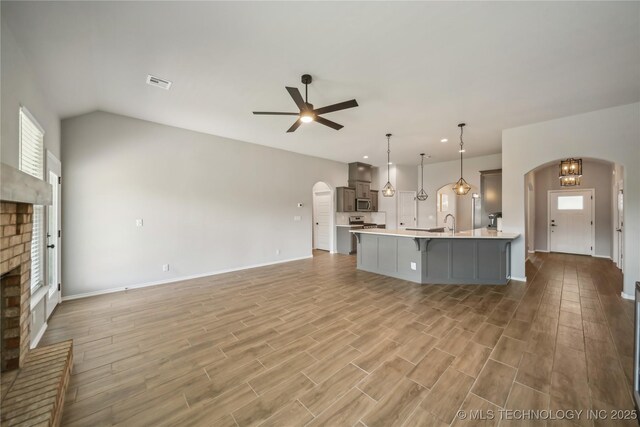 11807 N 131st E Ave, Owasso, OK 74055 - kitchen with arched walkways, a breakfast bar, light countertops, a ceiling fan, and open floor plan