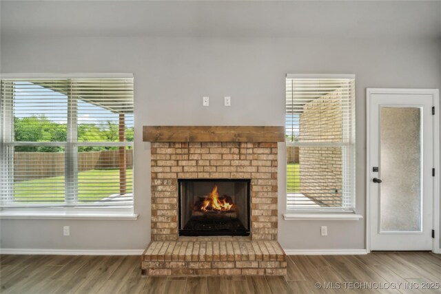 11807 N 131st E Ave, Owasso, OK 74055 - unfurnished living room with wood finished floors, healthy amount of natural light, and a brick fireplace