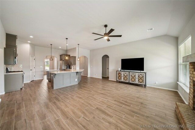 11807 N 131st E Ave, Owasso, OK 74055 - kitchen featuring arched walkways, light countertops, a ceiling fan, plenty of natural light, and vaulted ceiling