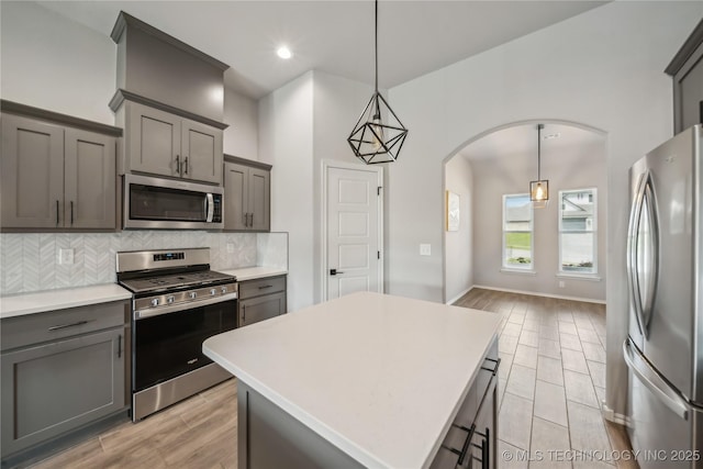 11807 N 131st E Ave, Owasso, OK 74055 - kitchen with stainless steel appliances, arched walkways, decorative backsplash, gray cabinetry, and light countertops