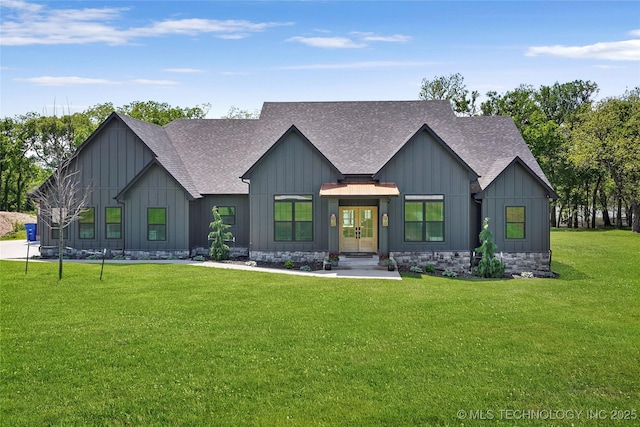 back of property featuring roof with shingles, board and batten siding, and a yard
