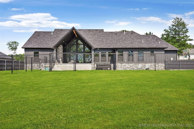 rear view of house featuring a shingled roof and stone siding