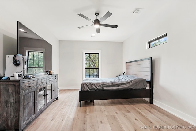 bedroom featuring multiple windows, light wood-style floors, baseboards, and ceiling fan