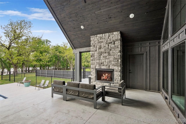 view of patio with fence and an outdoor living space with a fireplace