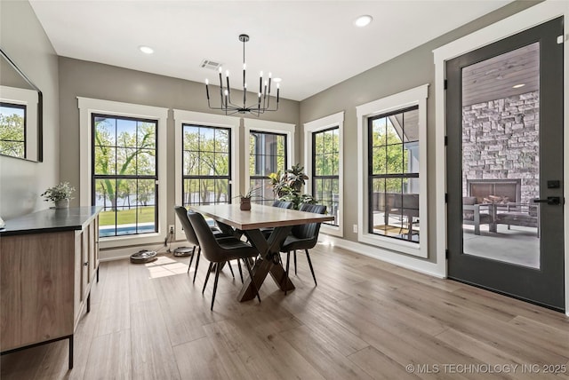 dining space with light wood-style floors, a chandelier, baseboards, and recessed lighting