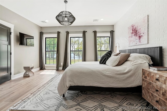 bedroom featuring light wood finished floors, multiple windows, baseboards, and recessed lighting