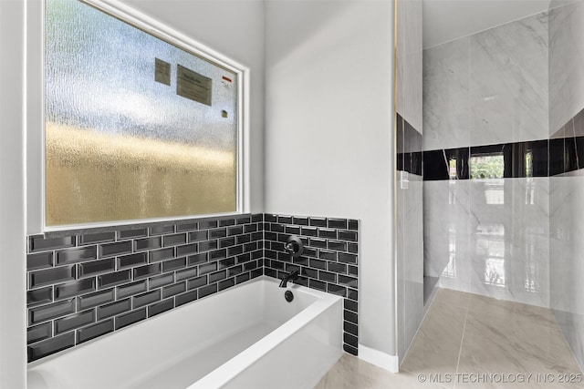 full bathroom with a bath and marble finish flooring