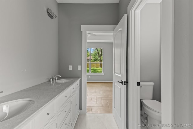 bathroom with toilet and double vanity