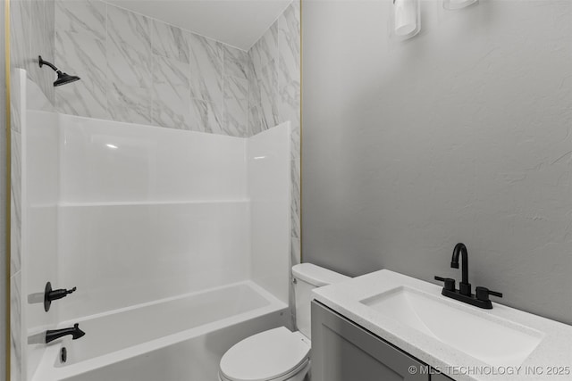 bathroom featuring a textured wall, toilet, bathtub / shower combination, and vanity