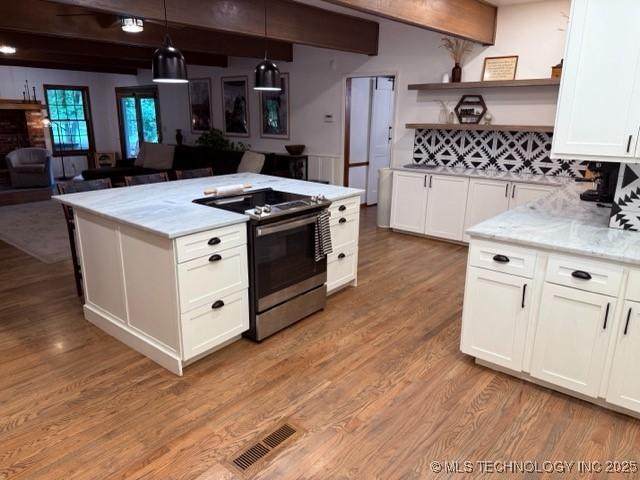 15373 N Javine Hill Rd, Skiatook, OK 74070 - kitchen with electric range, open shelves, beamed ceiling, light wood finished floors, and white cabinetry