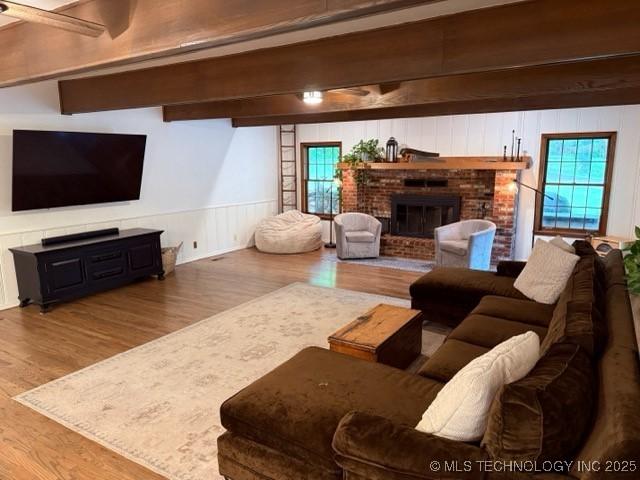 15373 N Javine Hill Rd, Skiatook, OK 74070 - living area with wood finished floors, a brick fireplace, beam ceiling, and a decorative wall