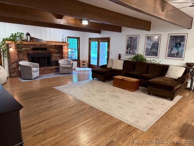 15373 N Javine Hill Rd, Skiatook, OK 74070 - living room with beam ceiling, wood finished floors, a fireplace, and a ceiling fan