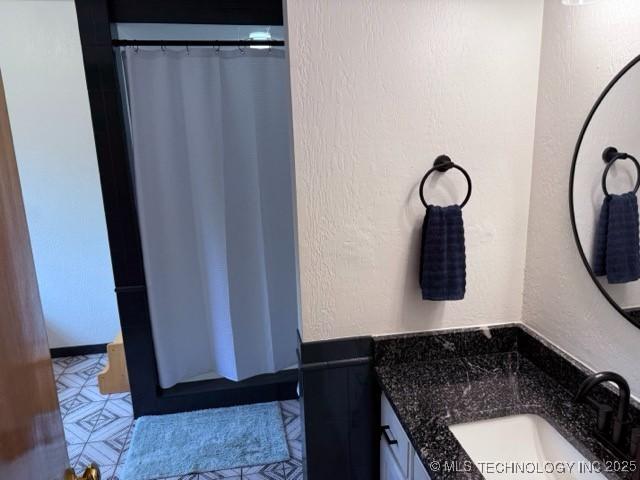 15373 N Javine Hill Rd, Skiatook, OK 74070 - bathroom featuring a textured wall, vanity, and a shower with shower curtain