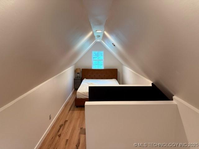 15373 N Javine Hill Rd, Skiatook, OK 74070 - unfurnished bedroom featuring vaulted ceiling, light wood finished floors, and baseboards